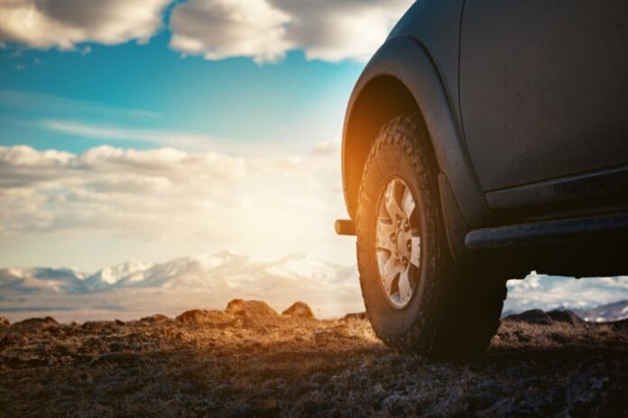 All-Terrain Tire of an SUV silhouetted by the sunset