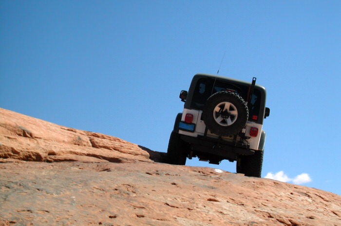 Jeep driving up sandstone hill