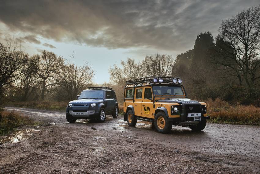 Two limited edition Land Rovers on a wet dirt road in the woods