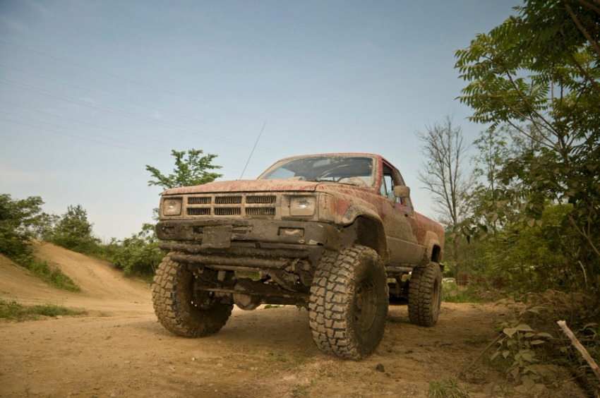 Low angle of a truck driving on a dirt road
