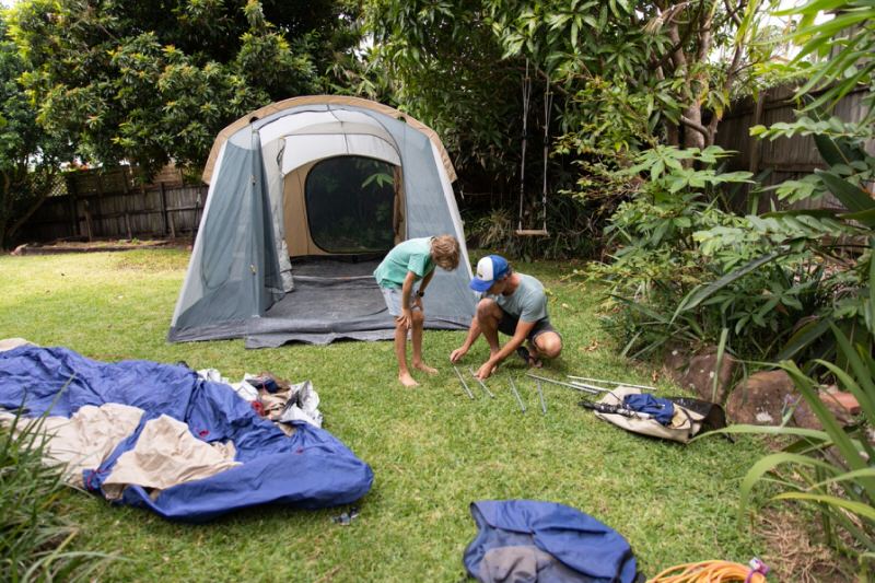 People setting up tent in the backyard