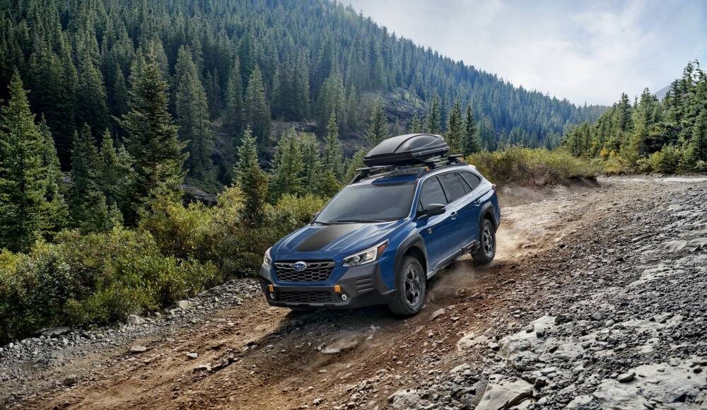 2022 Subaru Outback Wilderness driving on a dirt road in the mountians