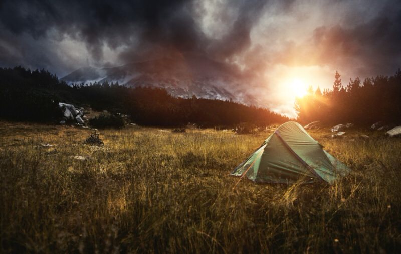 Tent in a meadow at sunset