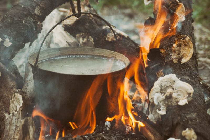 Steel pot with lid on an open campfire