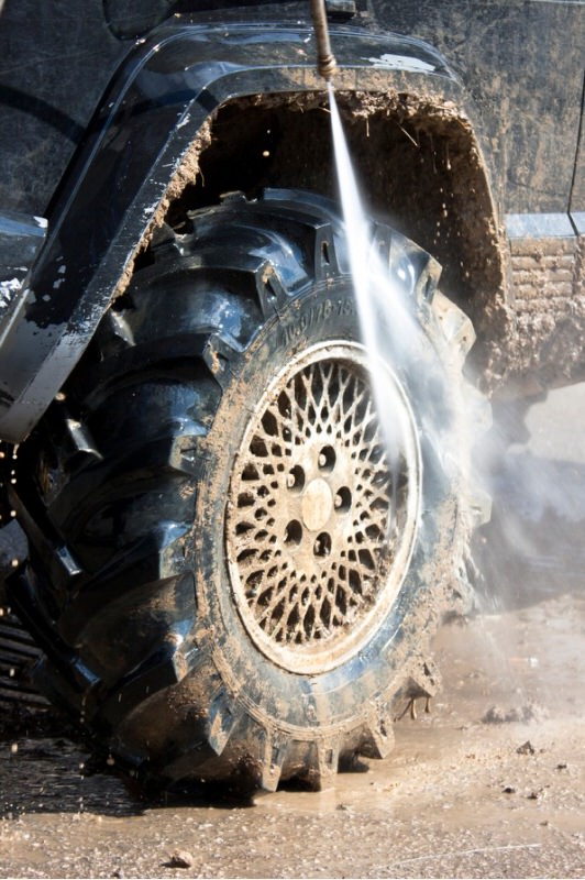 Power washing a muddy tire from a 4x4