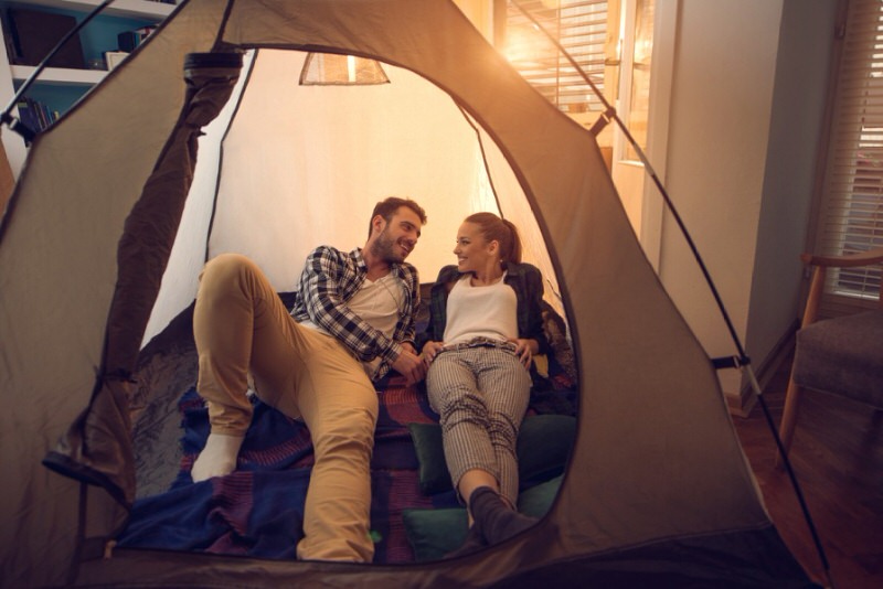 people relaxing in a tent set up in their living room