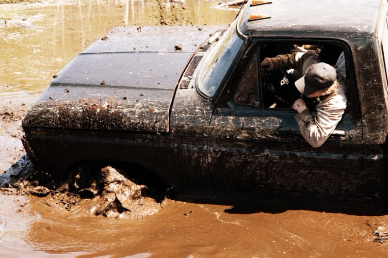 man recovering a 4WD stuck in high water and mud