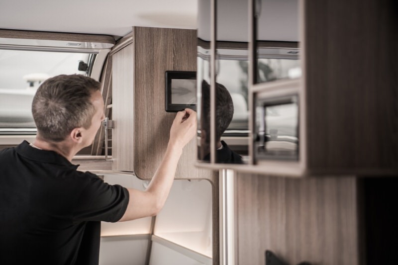 Man fixing a small screen in a travel trailer