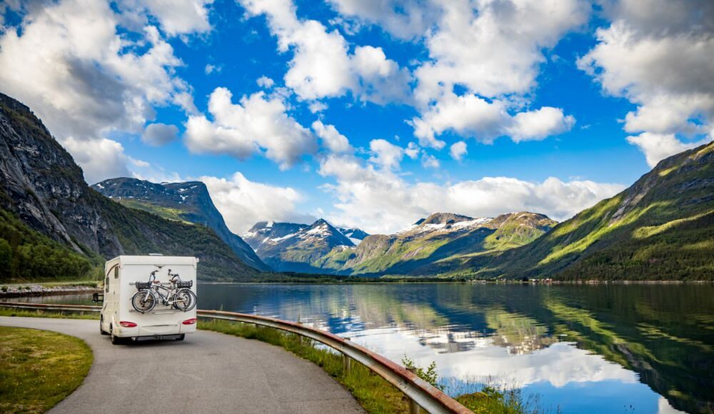 RV driving on a mountain road beside a river