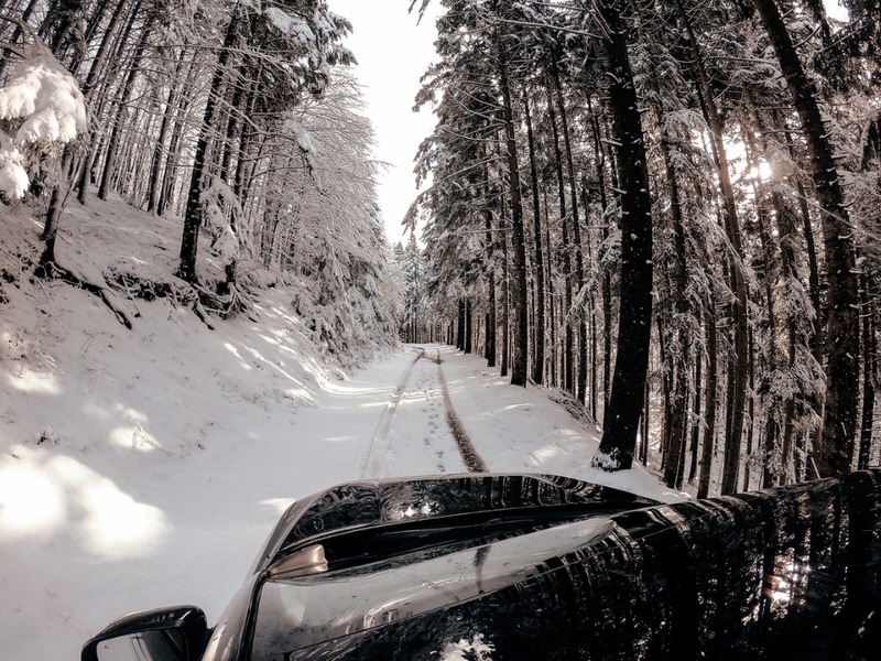 SUV driving up a snowy hill in the forest