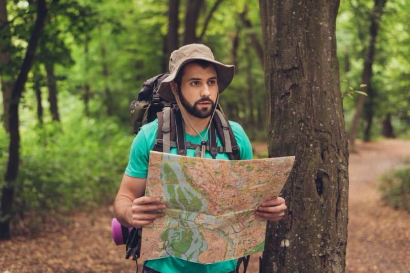Man holding a map in the forest