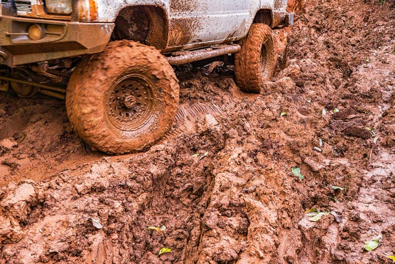 Close up of muddy tires tackling mud when off-roading