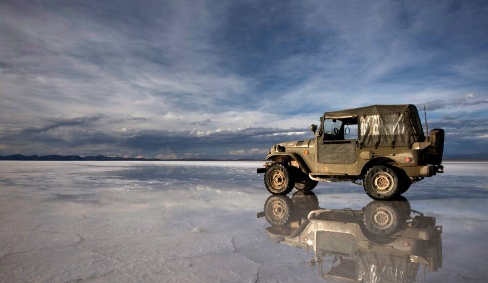 Jeep with minimum ground clearance driving on a salt flat