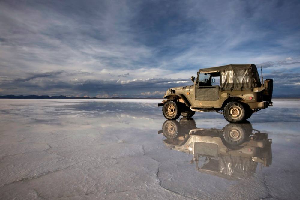 Jeep with minimum ground clearance driving on a salt flat