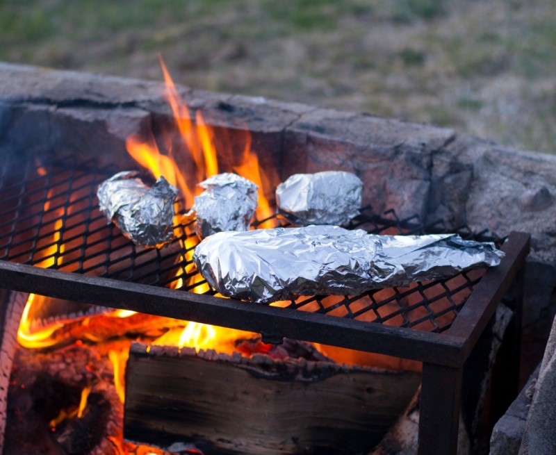food wrapped in foil cooking over a fire