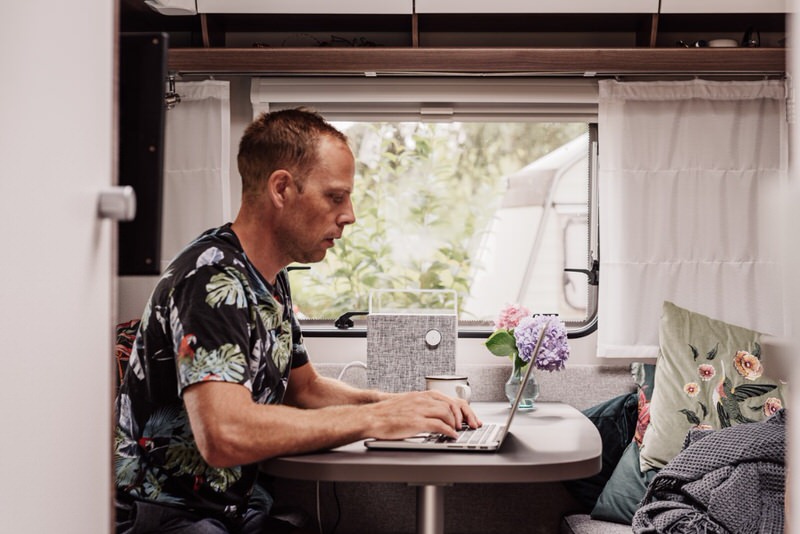 Man working on an laptop in a camper