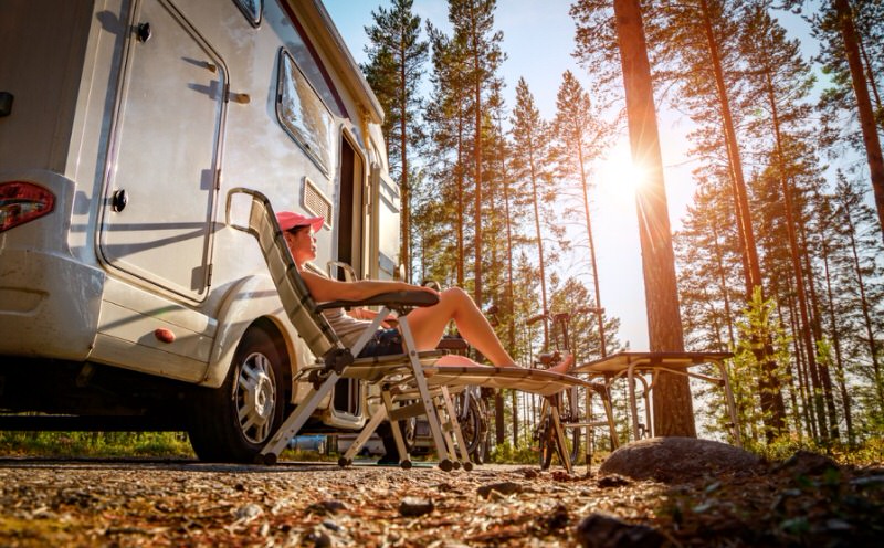 person relaxing outside of a camper