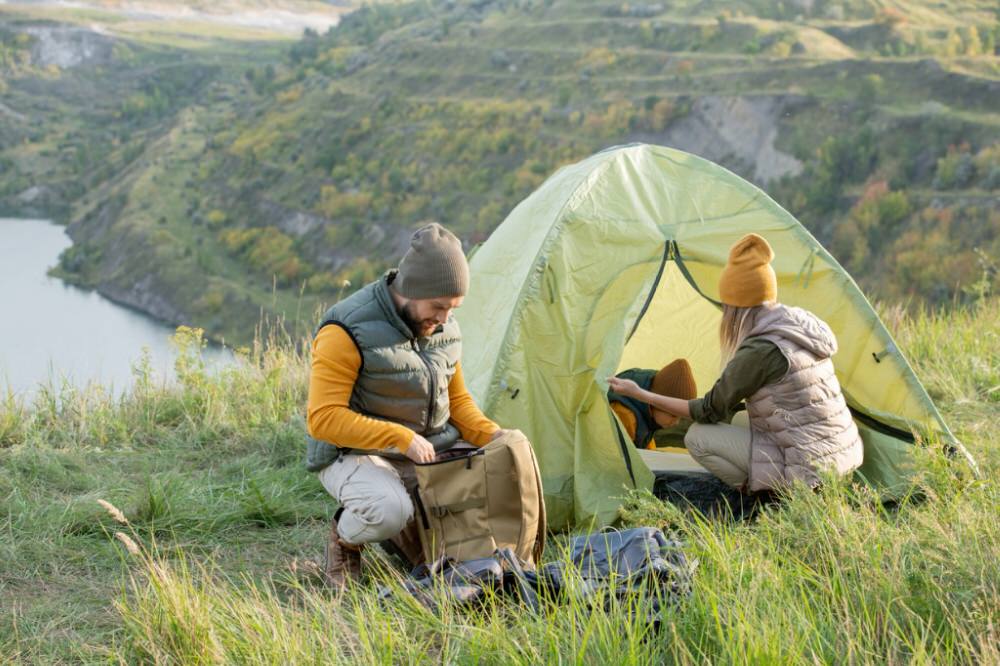 two people setting up a campsite