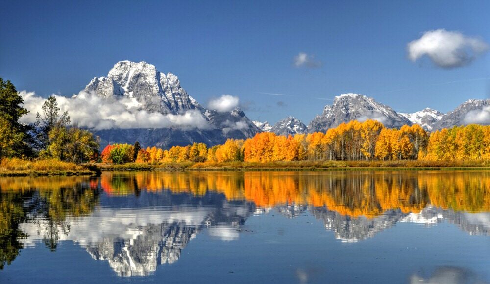Tetons and fall colors reflected in a lake