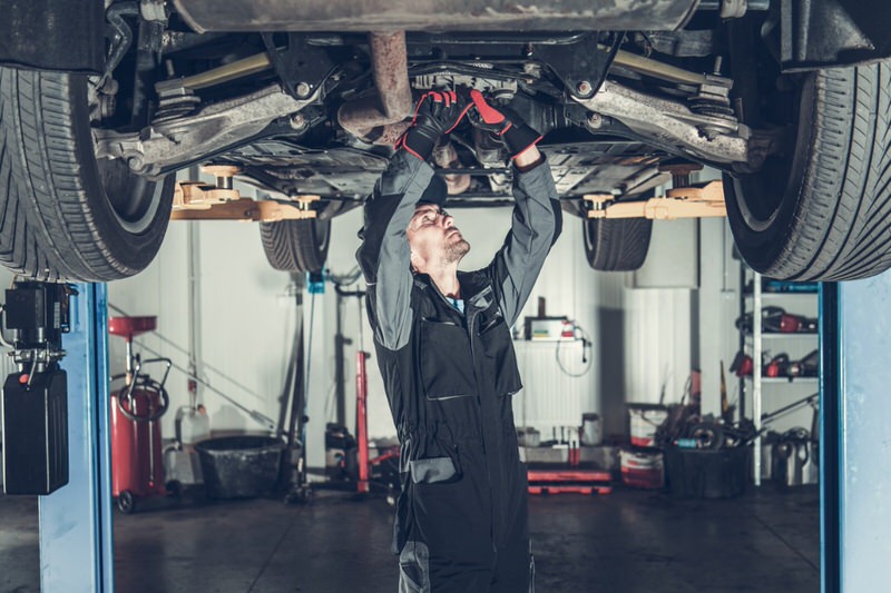 Mechanic working on the underside of an SUV