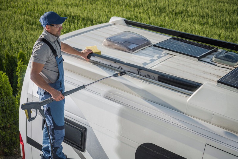 man cleaning camper roof
