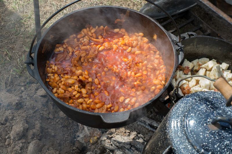 Beans in a cast iron pot on a campfire for an easy campfire recipe
