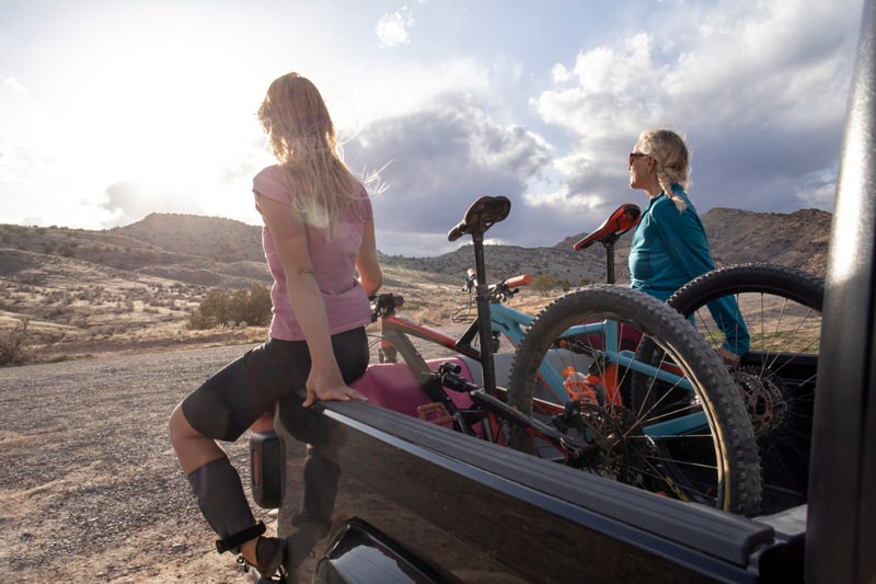 women with mountain bikes in back of pickup truck
