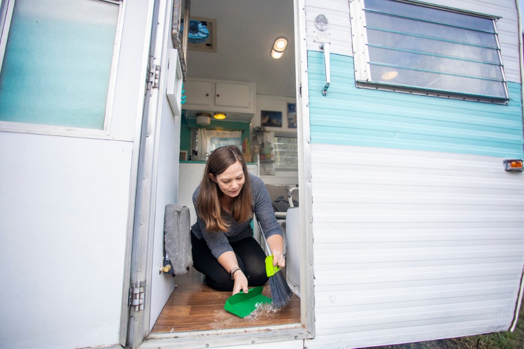 woman cleaning the floors of a camper