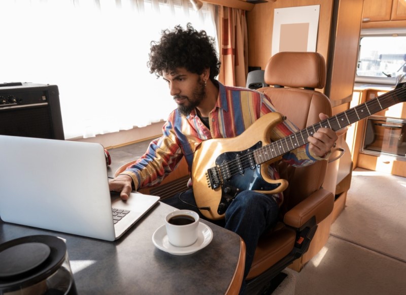man with a guitar in a camper as a digital nomad