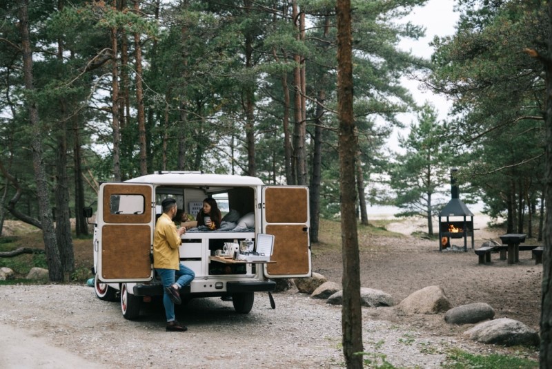 People relaxing by a camper