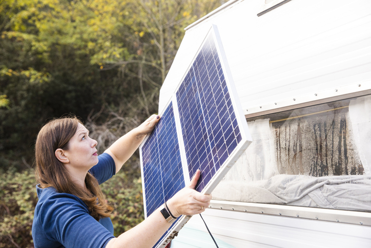 Woman installing solar panels on an RV