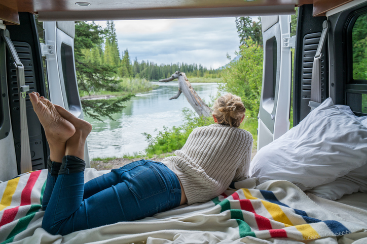 Young woman having a stunning view out of the back of her Camping Van
