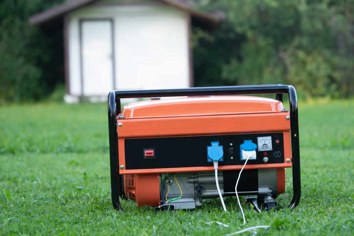 Portable electric generator on the backyard of a summer house outdoors