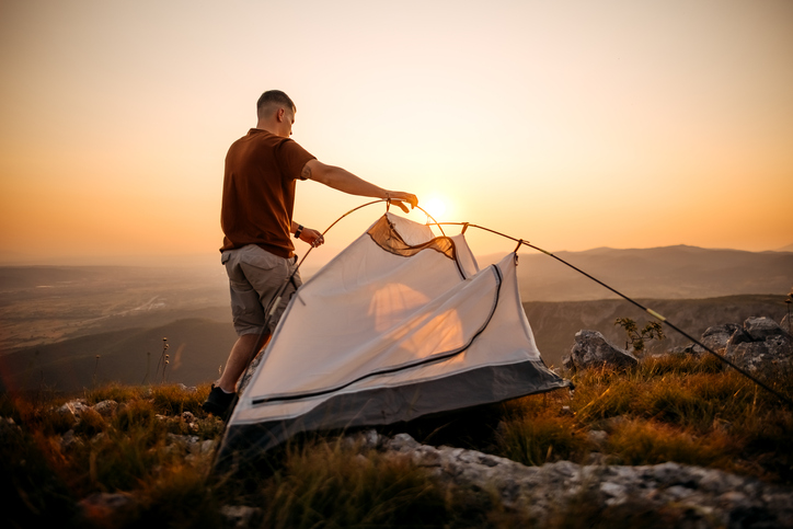 amping set up a tent at dusk