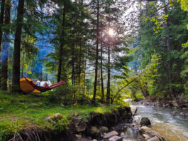 woman resting laying on hammock at camping site