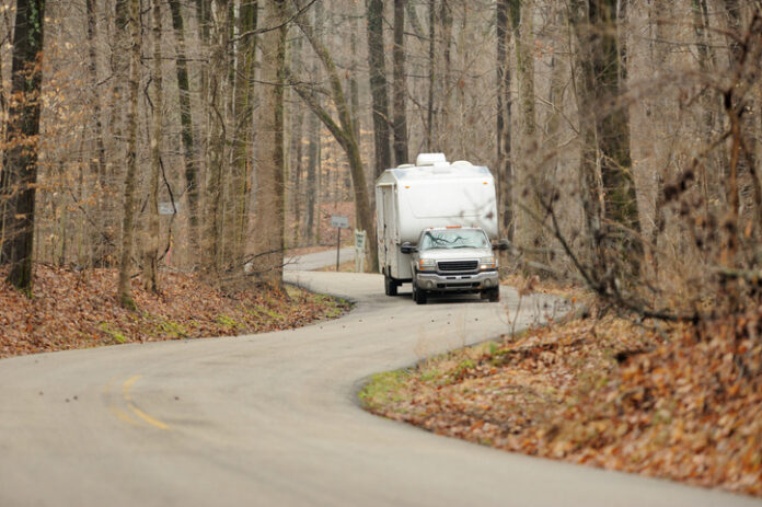 Travel trailer on winding road in woods