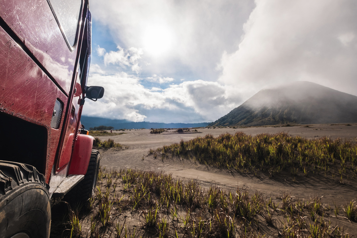 Red off road car at Bromo mountain, adventure trial