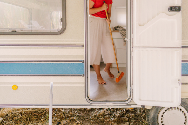 a young woman cleaning and sweeping the inside of her RV.