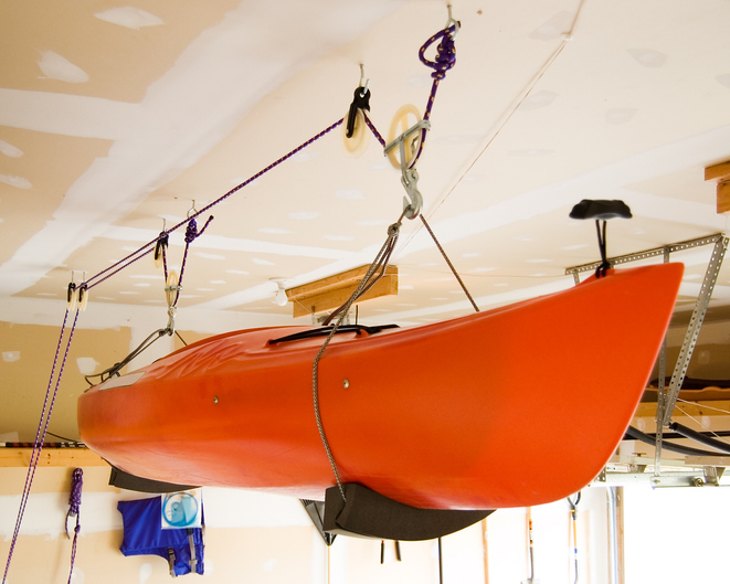 Kayak stored in a garage over winter using a home-made pulley system.