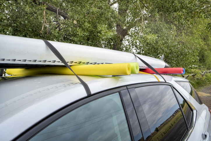 stand up paddleboard on a rental car roof, improvised fitting with straps and swimming pool foam noodles