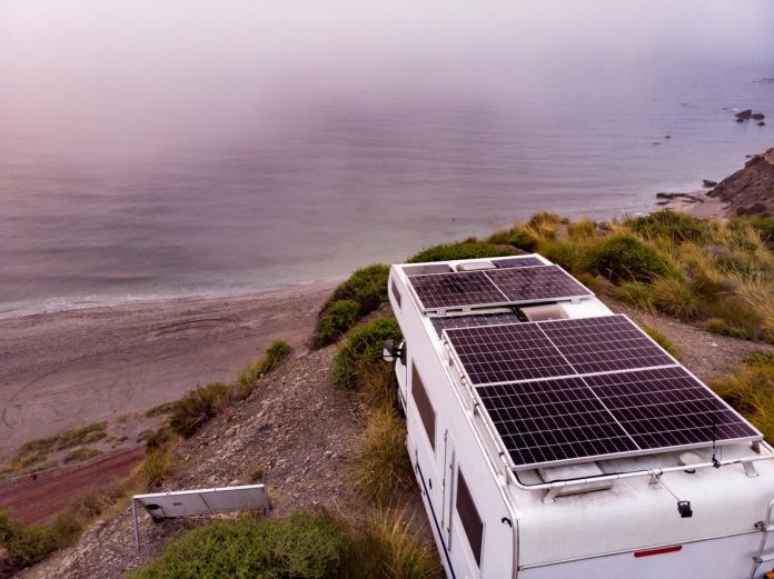 RV with solar panels on roof by coast