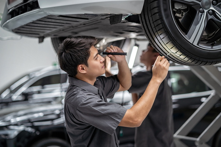 Asian mechanic Checking a tire in maintenance 