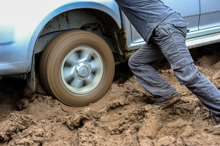 Man trying to save off-road vehicle skidding on muddy road