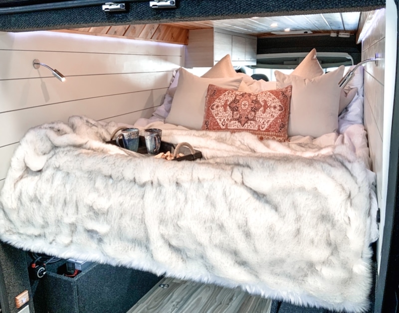 Bed in a Ram ProMaster van by Camplife Customs