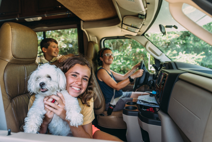Children and mom in a camper with a white dog