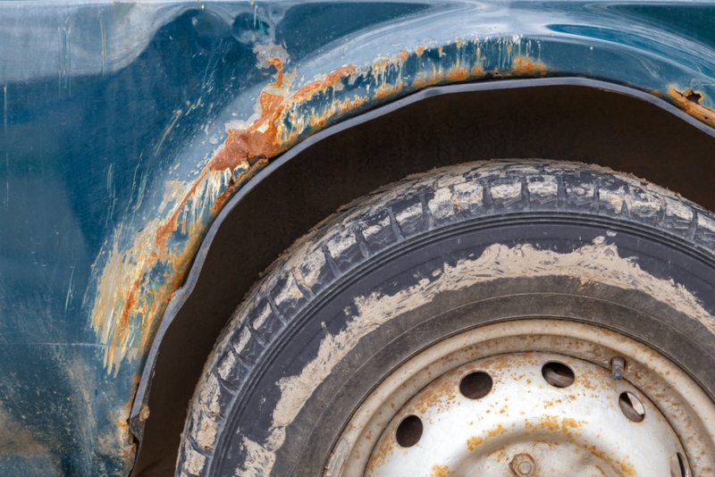 rusted off-road vehicle, close-up view on wing and wheel arch with heavy rust